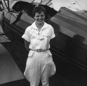 Image description: A black-and-white photo of Ruth Harman Walraven standing in front of a plane.