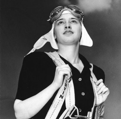 Image description: A black-and-white photo of Dickey Chapelle in her parachute gear.