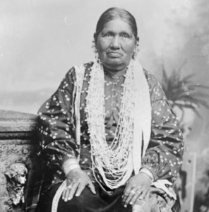 Image description: A black-and-white photo of Betsy Thunder wearing her traditional clothing.