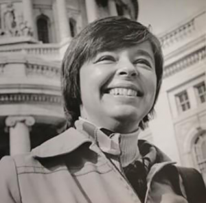 Image description: A black-and-white headshot of Kathryn Morrison in front of Madison’s Capitol building.