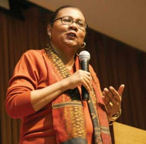 A photo of bell hooks speaking into a microphone.