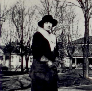 Image description: A black-and-white photo of Maud Neprud Otjen standing in front of bare trees.