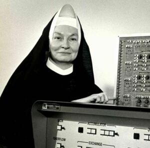 Image description: A black-and-white photo of Sister Mary Kenneth Keller next to an old computer.